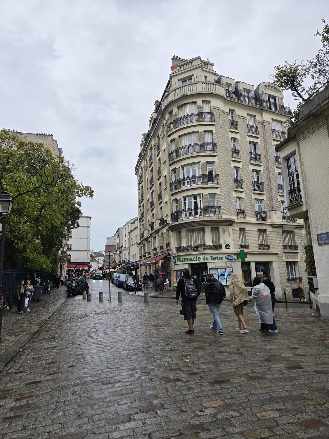 Calle de París bajo la lluvia, con edificios haussmanianos